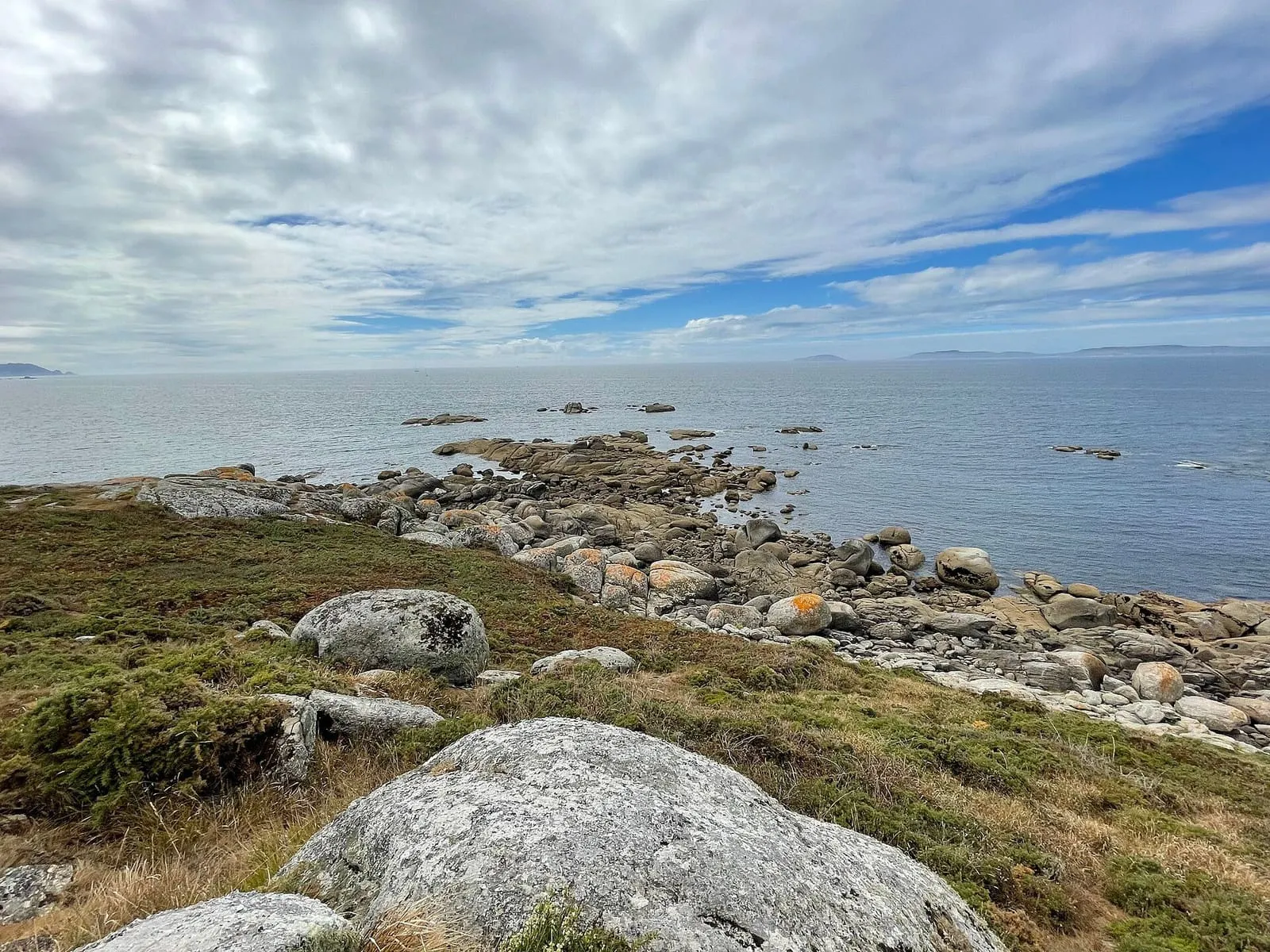 Costa de granito de Cabo Udra con rocas redondeadas y el mar al fondo