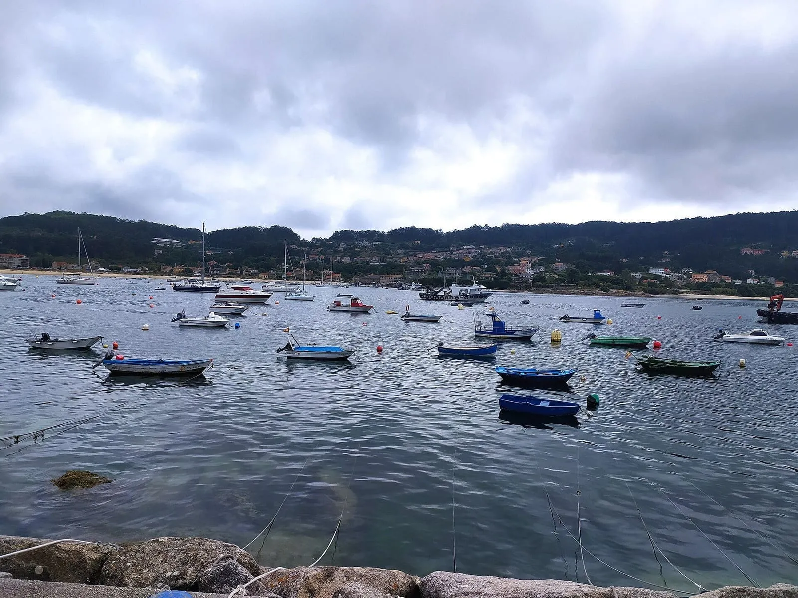 Barcas fondeadas en la ría de Aldán, con las casas y los montes de la orilla al fondo