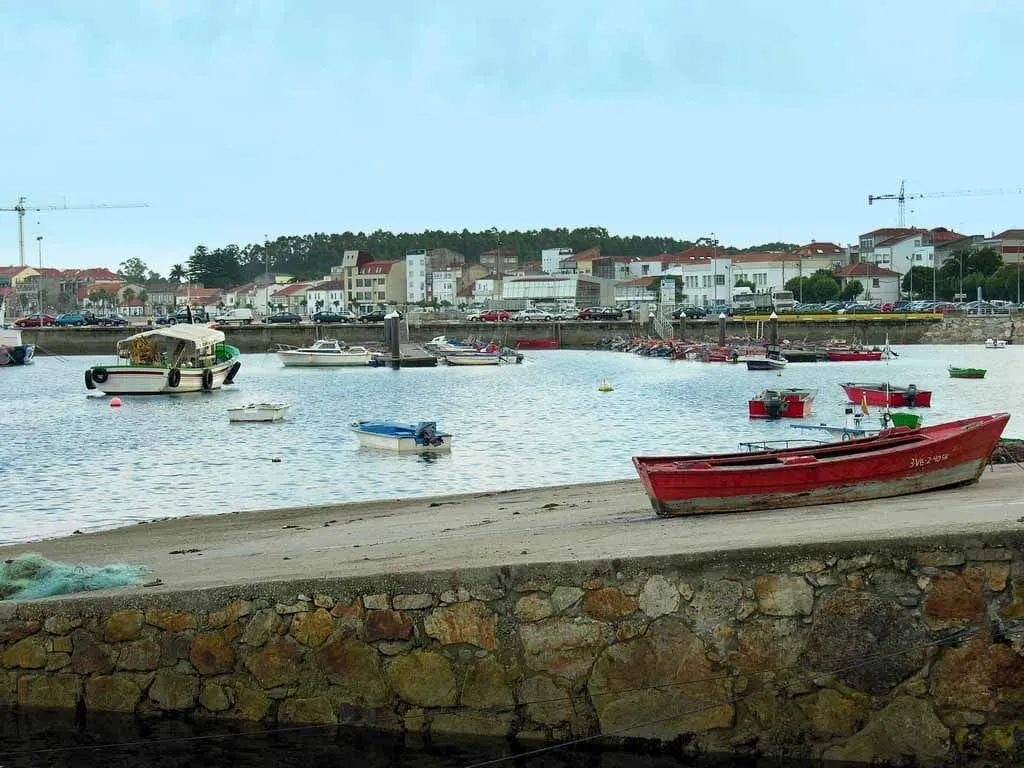 Barcas junto al muelle del puerto de A Pobra do Caramiñal, con el pueblo al fondo