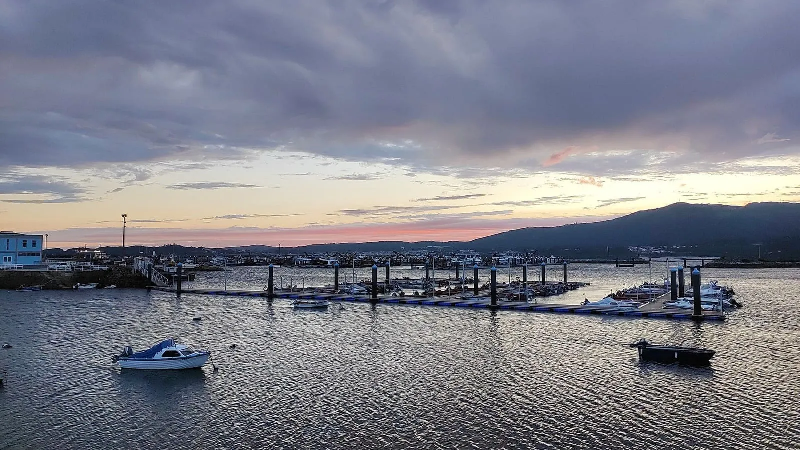 Atardecer sobre el puerto deportivo de Cabo de Cruz, con barcas y montes al fondo