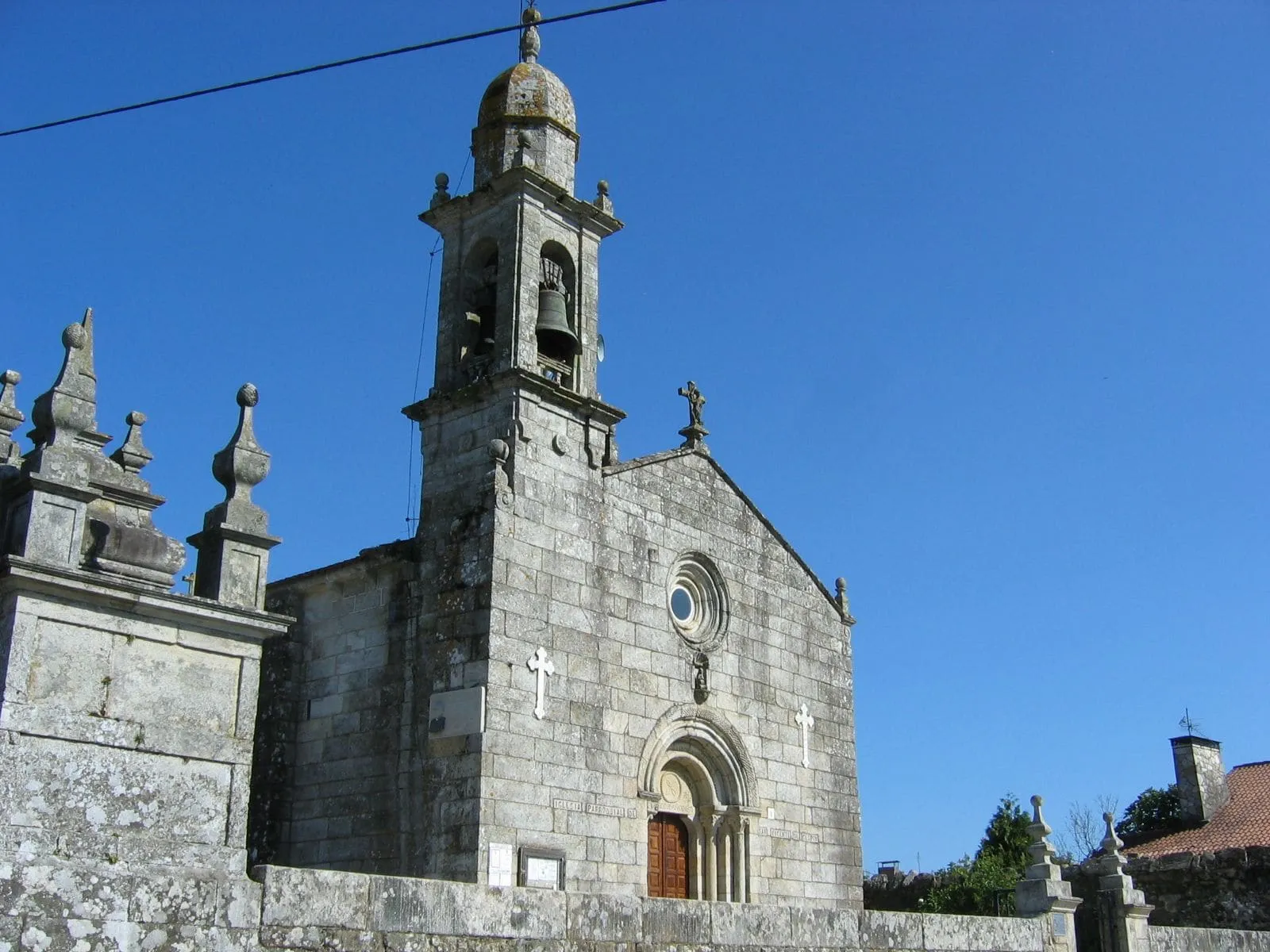 La iglesia románica de San Vicenzo de Cespón con su torre campanario y los pináculos del cierre del atrio