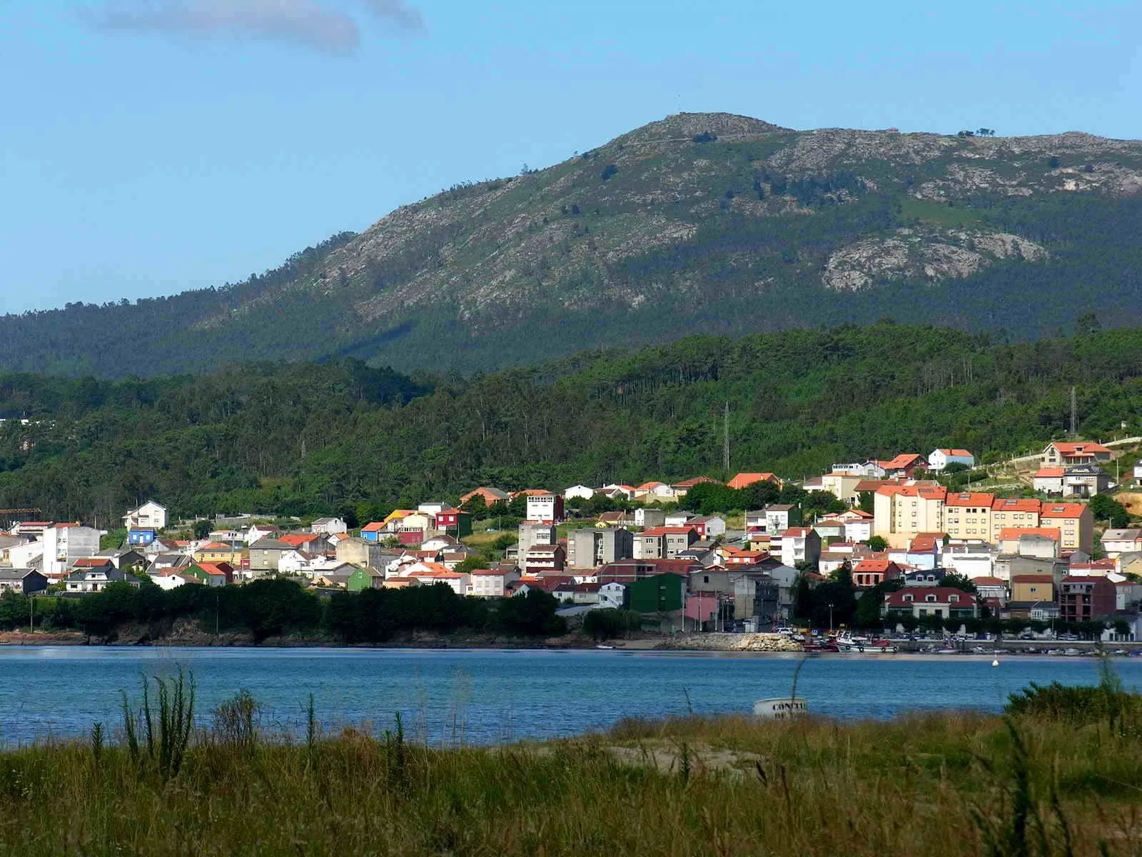 Casas de Boiro asomadas a la ría, con el monte al fondo