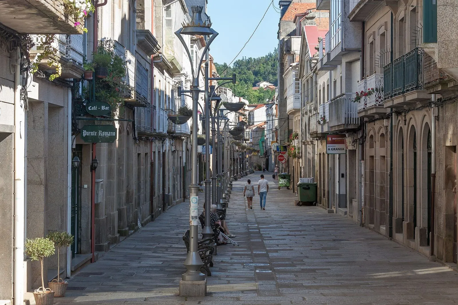 Calle peatonal de Caldas de Reis con casas con galerías y farolas