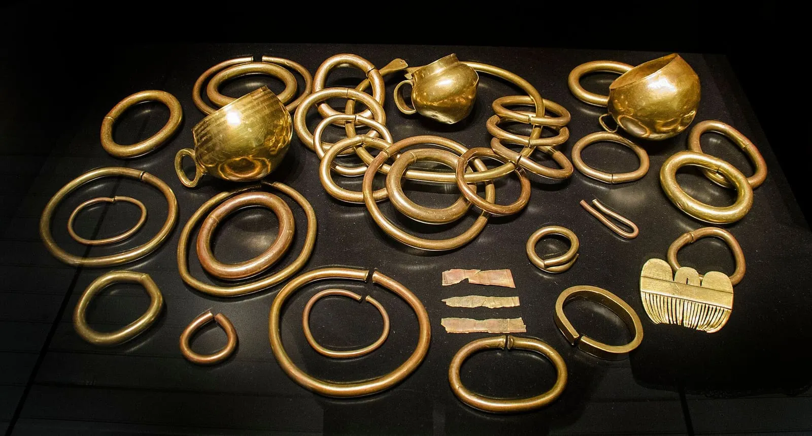 Aros, brazaletes y tazas de oro del Tesoro de Caldas expuestos en una vitrina del Museo de Pontevedra
