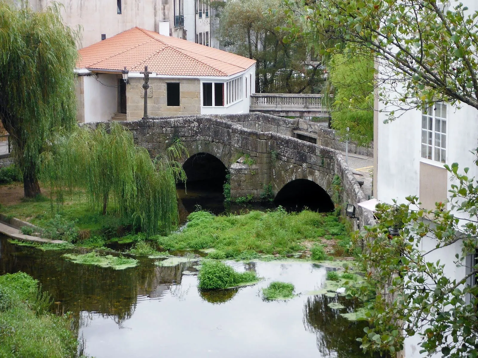 Puente romano de piedra sobre el río, en Caldas de Reis, con sauces a su lado