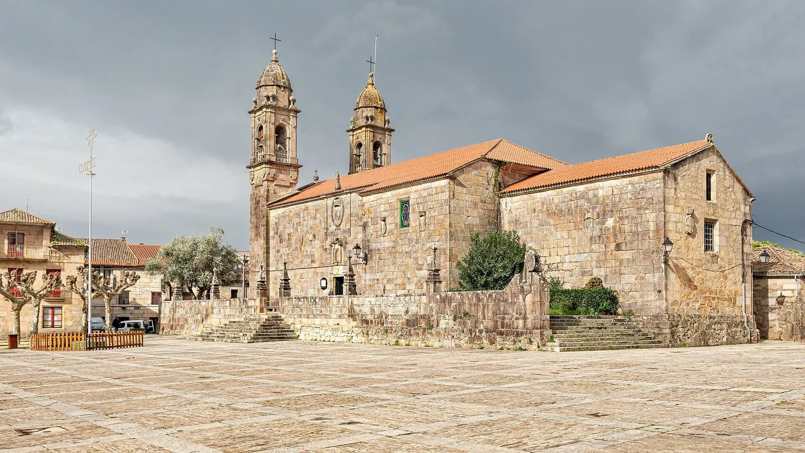 La iglesia de San Benito de Fefiñáns con sus dos torres y la plaza empedrada delante