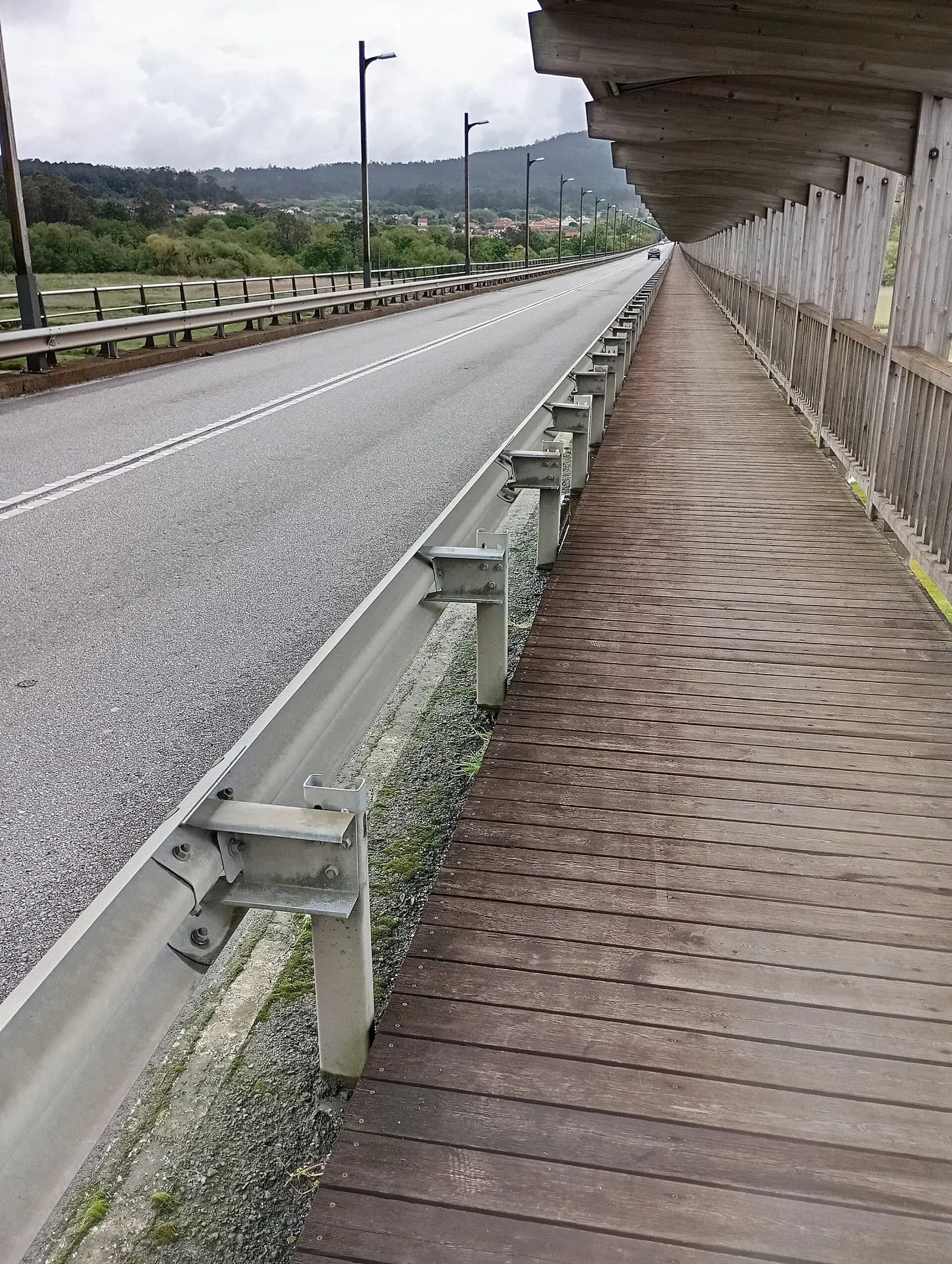 Pasarela de madera junto al viaducto de la ponte de Catoira, con el río Ulla y la ría de fondo