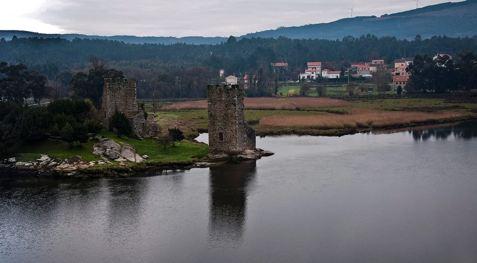 Las Torres do Oeste de Catoira, dos torres de piedra junto al río, entre la marisma y el arbolado