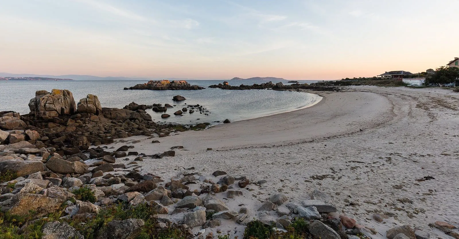 Playa de arena y rocas de granito en la costa de San Vicente do Grove, con el Atlántico al fondo