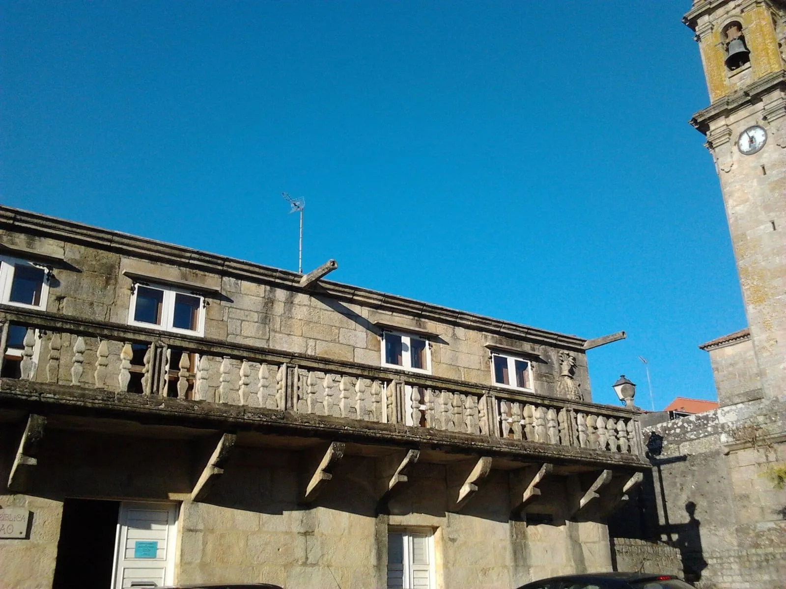 La balconada de piedra del pazo de Martelo, con balaustres y ventanas de madera, en la plaza de Rafael Dieste