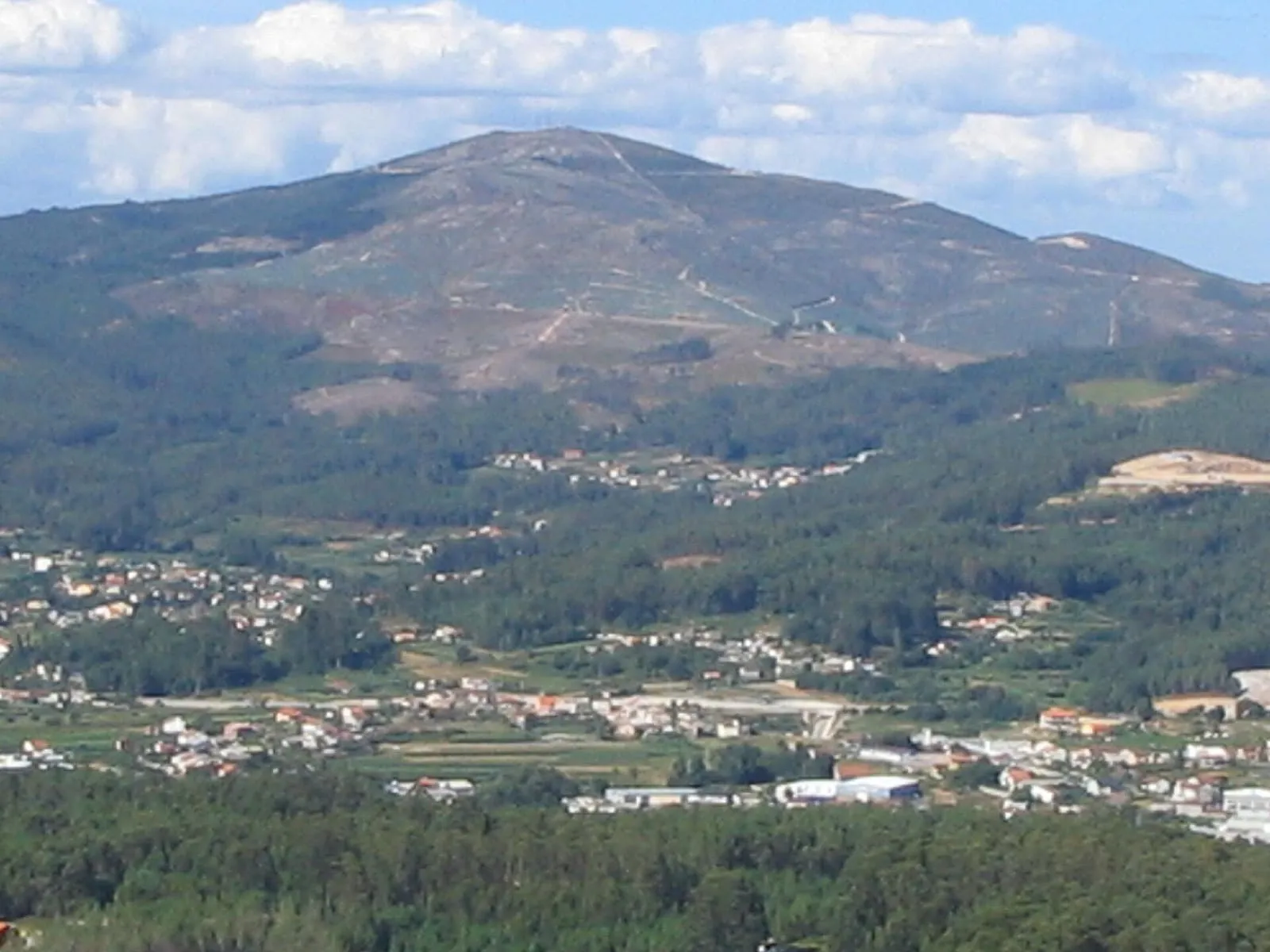 El monte Xiabre, una gran sierra de bosque, visto desde el valle con las casas de Vilagarcía