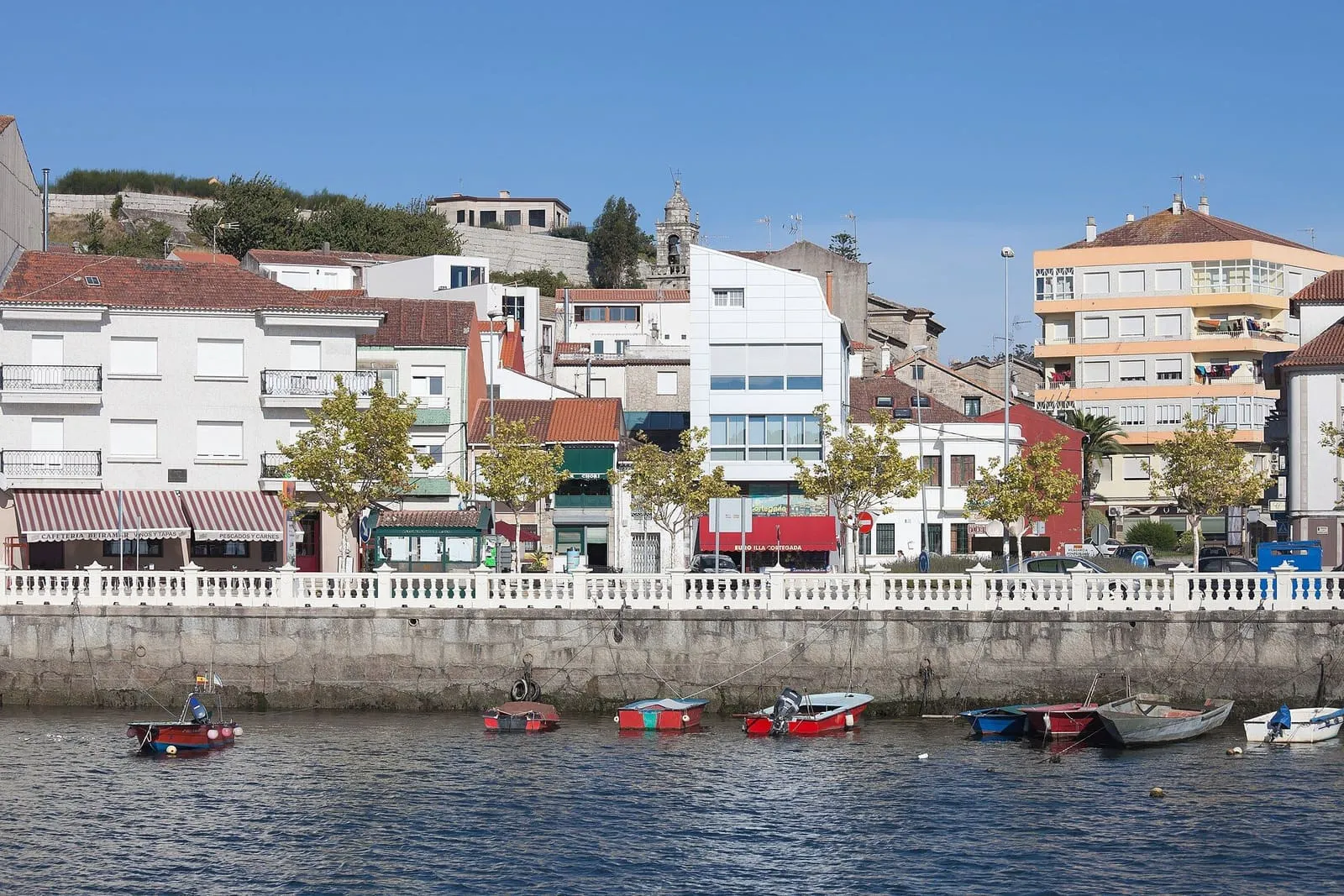 Frente marítimo de O Carril, en Vilagarcía de Arousa, con las casas sobre el paseo y las barcas
