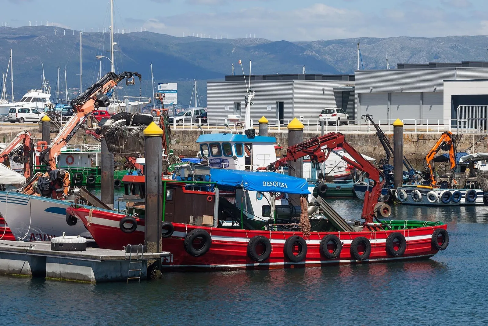 Barcos mejilloneros con grúas amarrados en el puerto de Vilanova de Arousa
