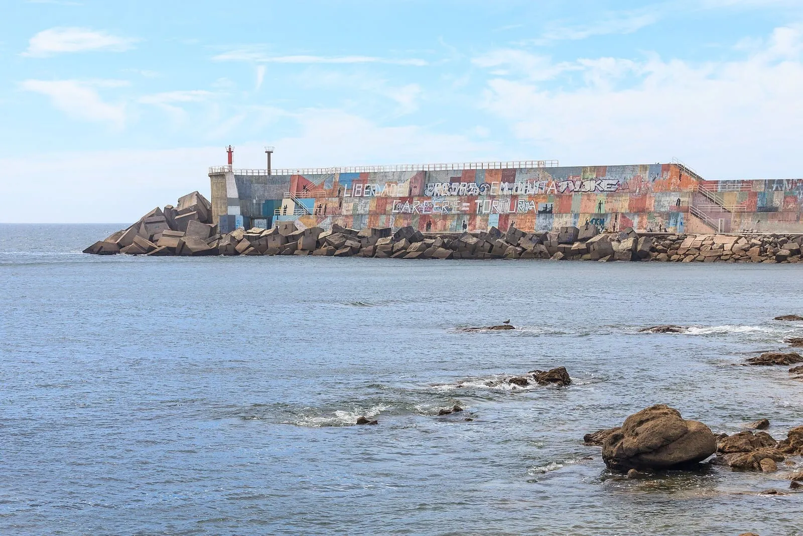 Dique norte del puerto de A Guarda cubierto por un gran mural de colores