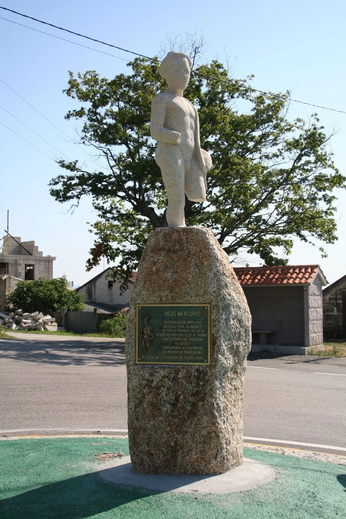 Monumento en Taboexa al dios Mercurio: una escultura sobre una roca de granito con una placa, junto a una marquesina de piedra