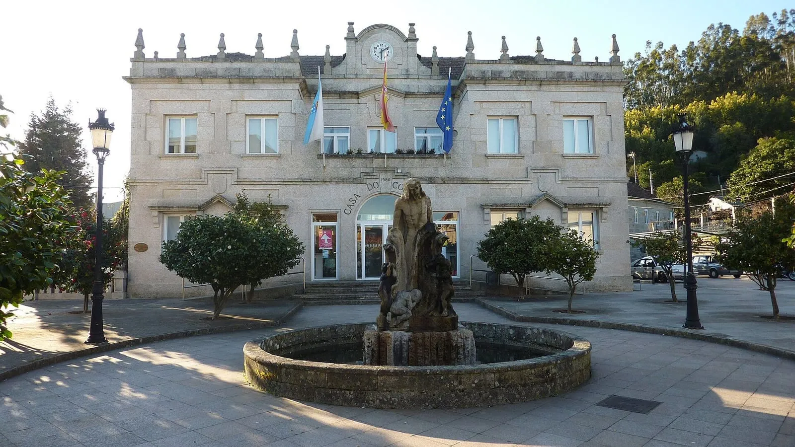 Casa do Concello de As Neves, edificio de piedra con fuente en la plaza