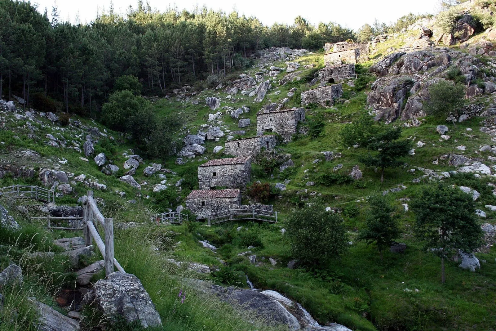 Los molinos de piedra del Folón, escalonados en la ladera junto al arroyo, entre rocas y vegetación