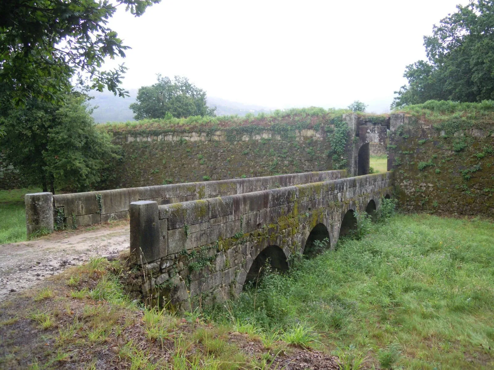 Puente de piedra de arcos y muralla de la fortaleza de Goián, en Tomiño