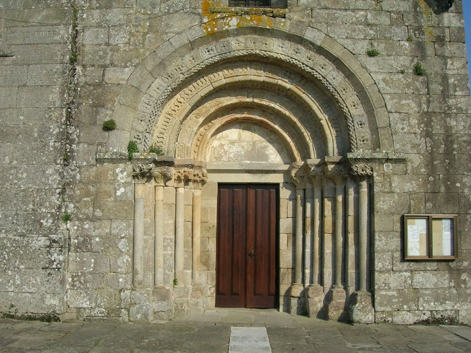 La portada románica de la iglesia de Santa María, con arquivoltas y columnas, y una puerta de madera