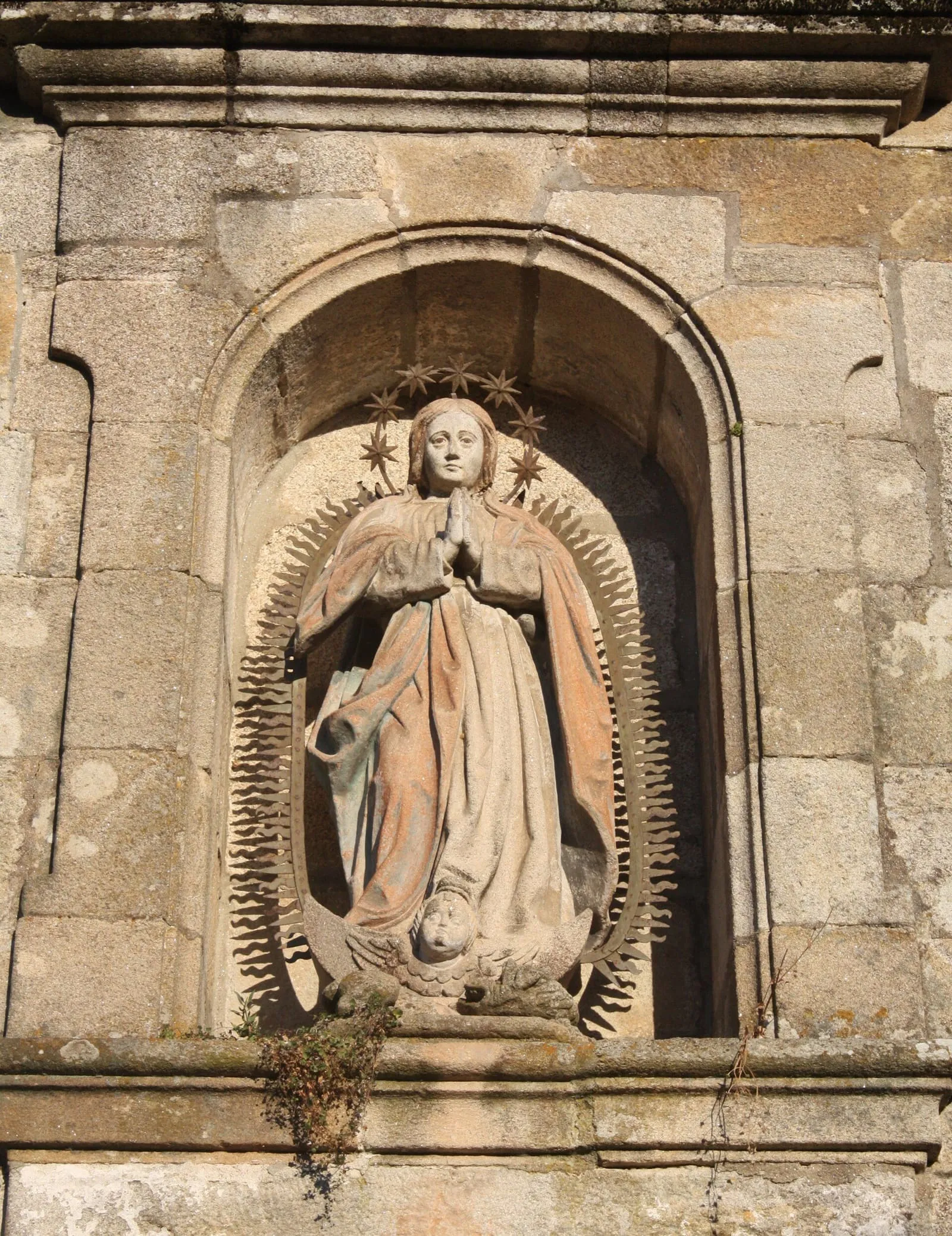 Una imagen de la Virgen en una hornacina de piedra con aureola en la fachada del convento de las Clarisas