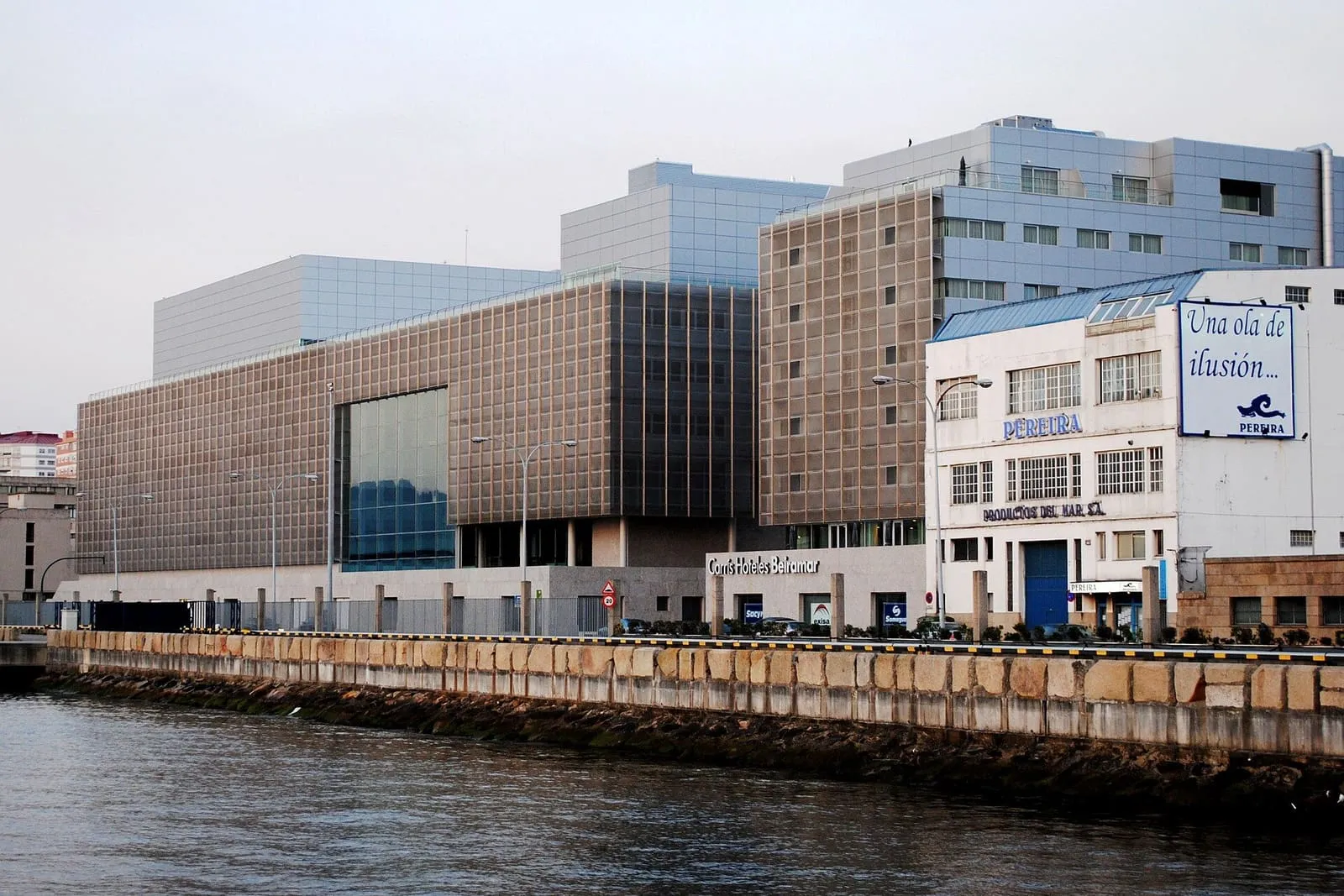 El Auditorio Mar de Vigo, de vidrio y piedra, sobre el muelle y visto desde el agua