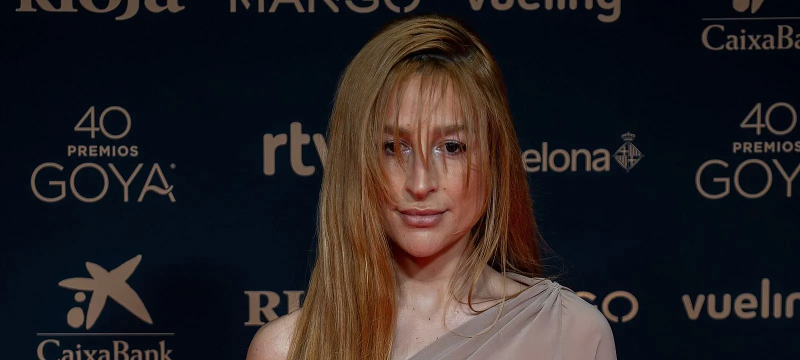 Retrato de Belén Aguilera, con el pelo largo y rubio, en la alfombra de los Premios Goya 2026