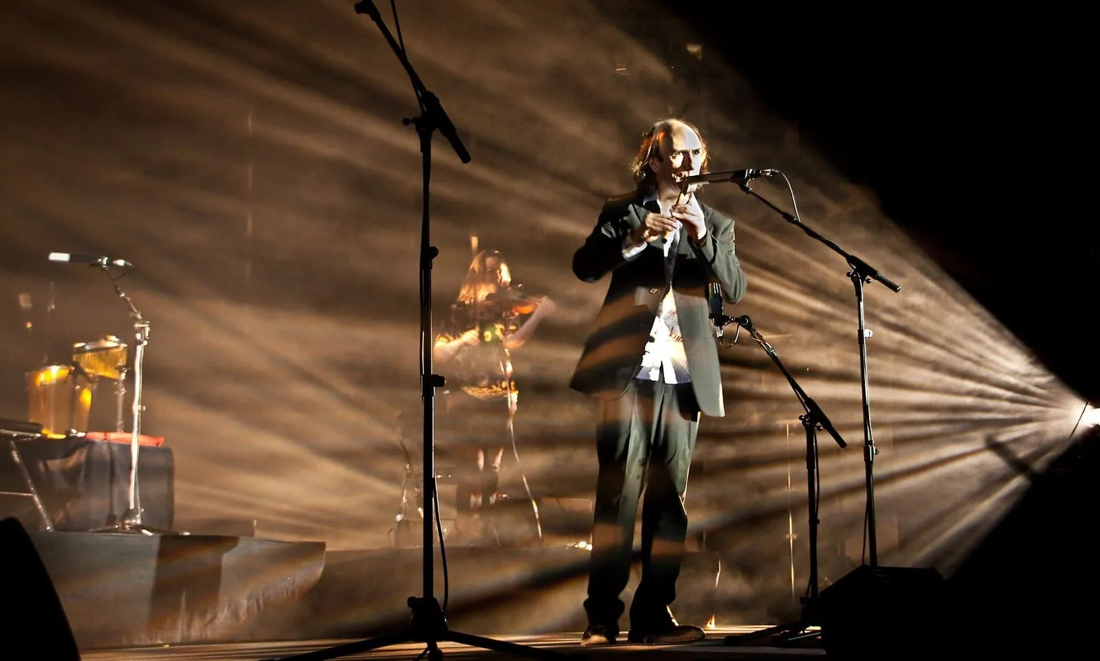 Carlos Núñez tocando la flauta en un escenario iluminado