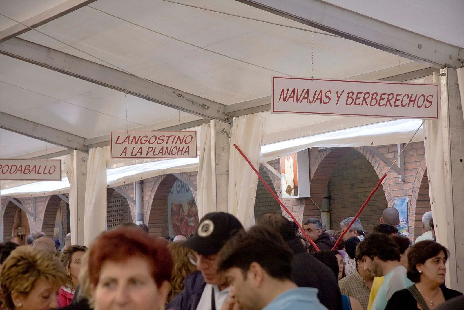 Carpas de la Festa do Marisco llenas de gente, con rótulos de navajas, berberechos y langostinos a la plancha