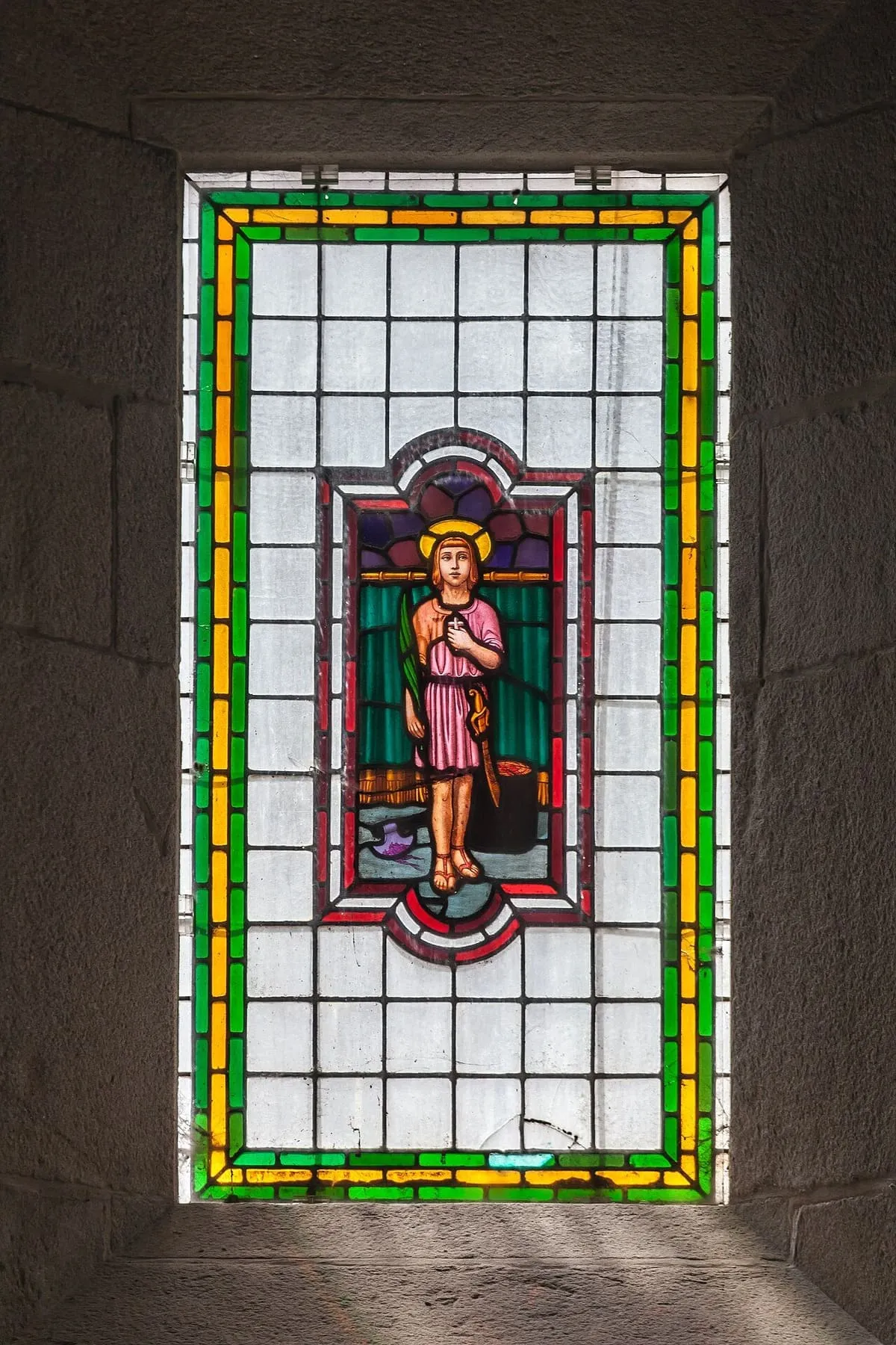 Vidriera de la iglesia con una figura infantil de túnica rosa