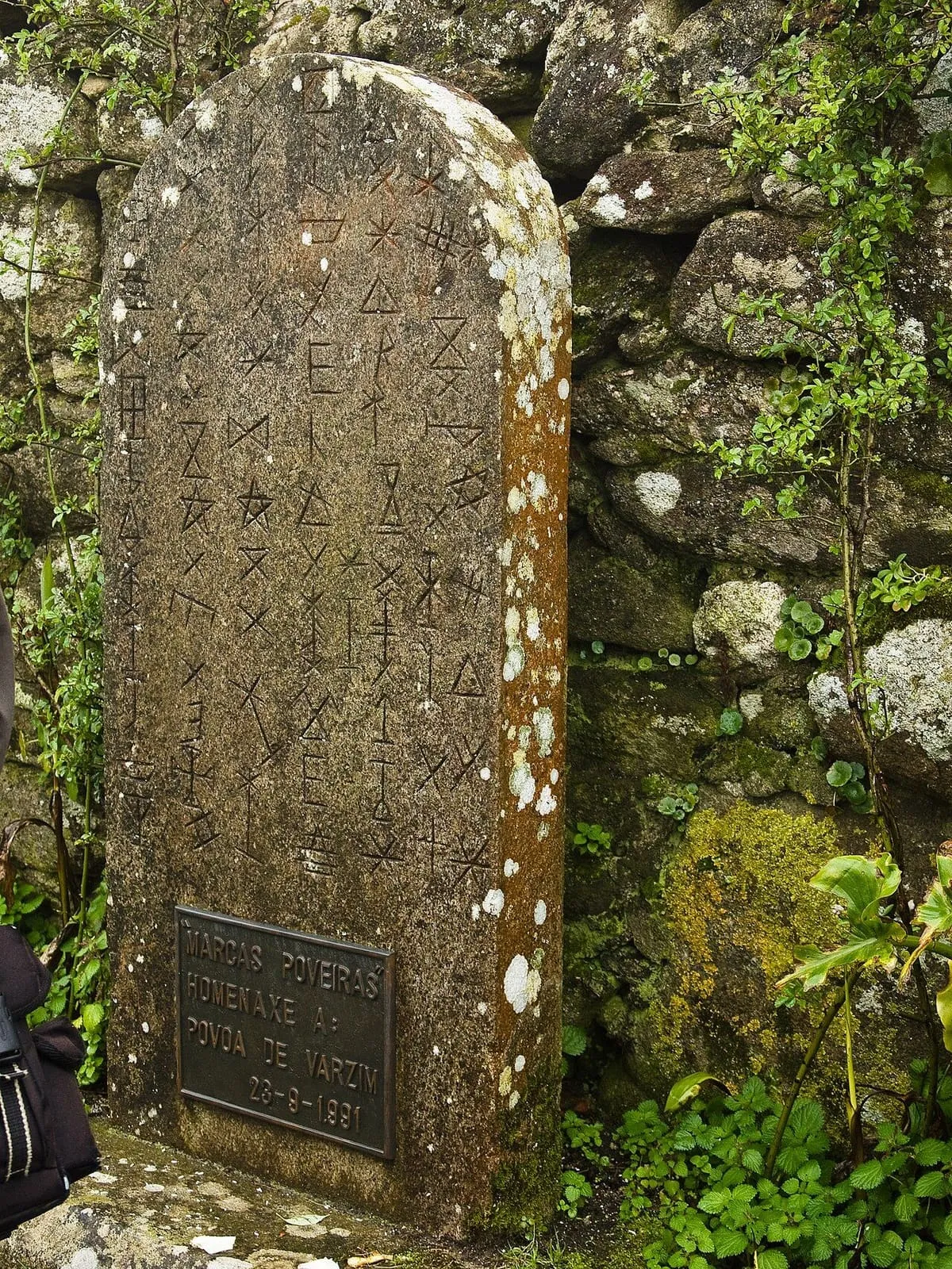 Una piedra tallada con siglas poveiras, marcas de los pescadores de Póvoa de Varzim, junto a la capela de Santa Trega
