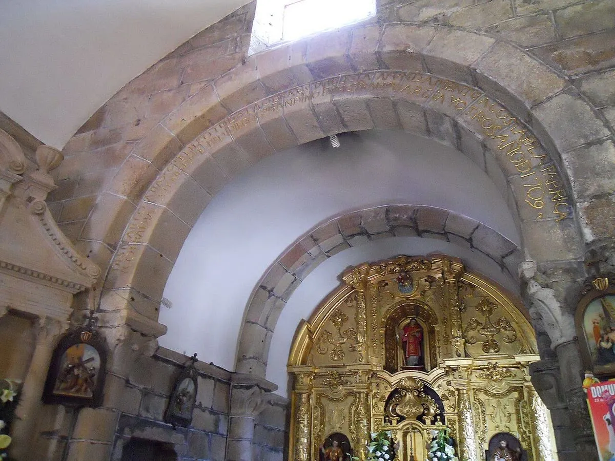 Arco de medio punto de la iglesia y el retablo barroco dorado al fondo