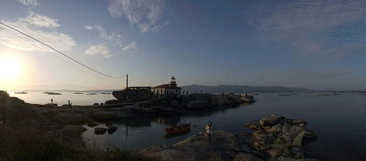 El faro de Punta Cabalo al atardecer sobre las rocas de la costa