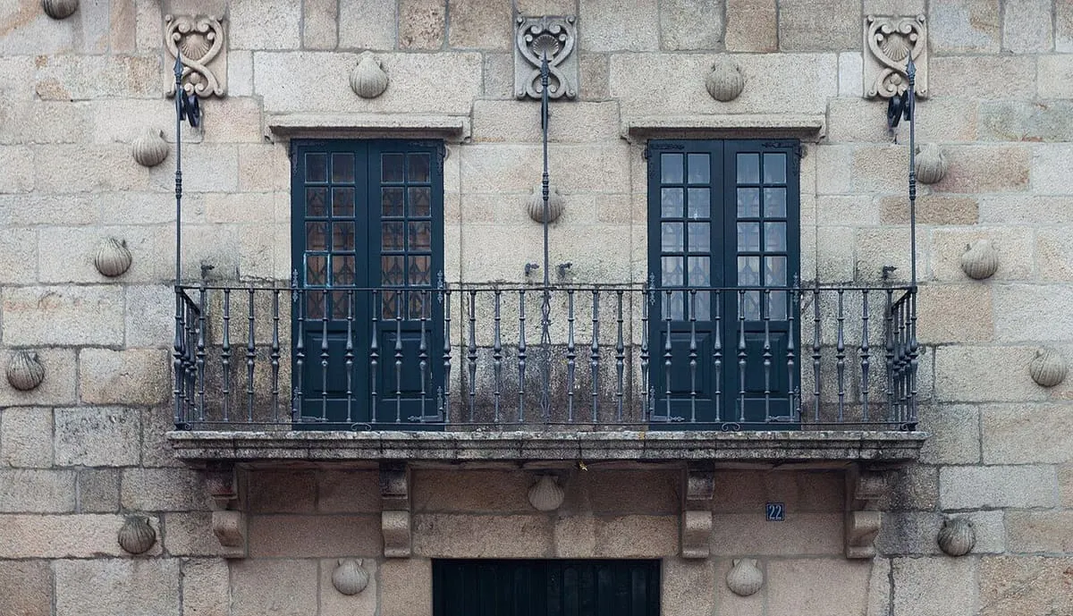 Balcón de hierro de la Casa das Cunchas, con la fachada de piedra decorada con vieiras