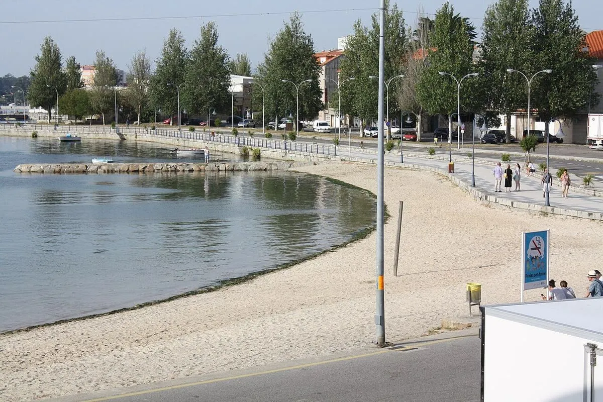Playa de Santo Tomé junto al paseo marítimo, con una pasarela y farolas