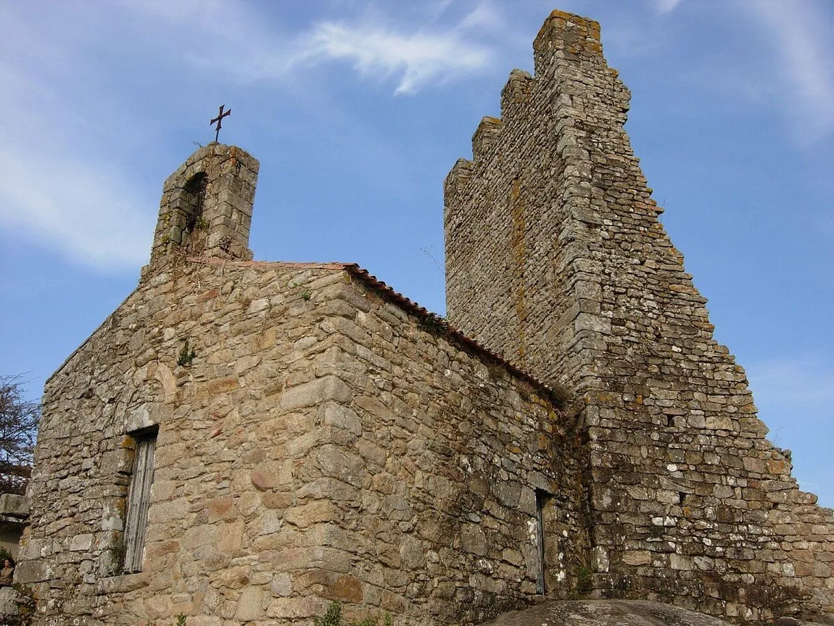 La pequeña capilla de piedra con espadaña junto a una de las torres, en las Torres do Oeste