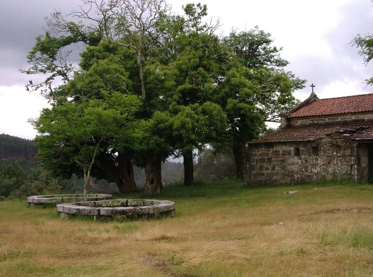 La capilla del castro de Troña, con su atrio y grandes árboles