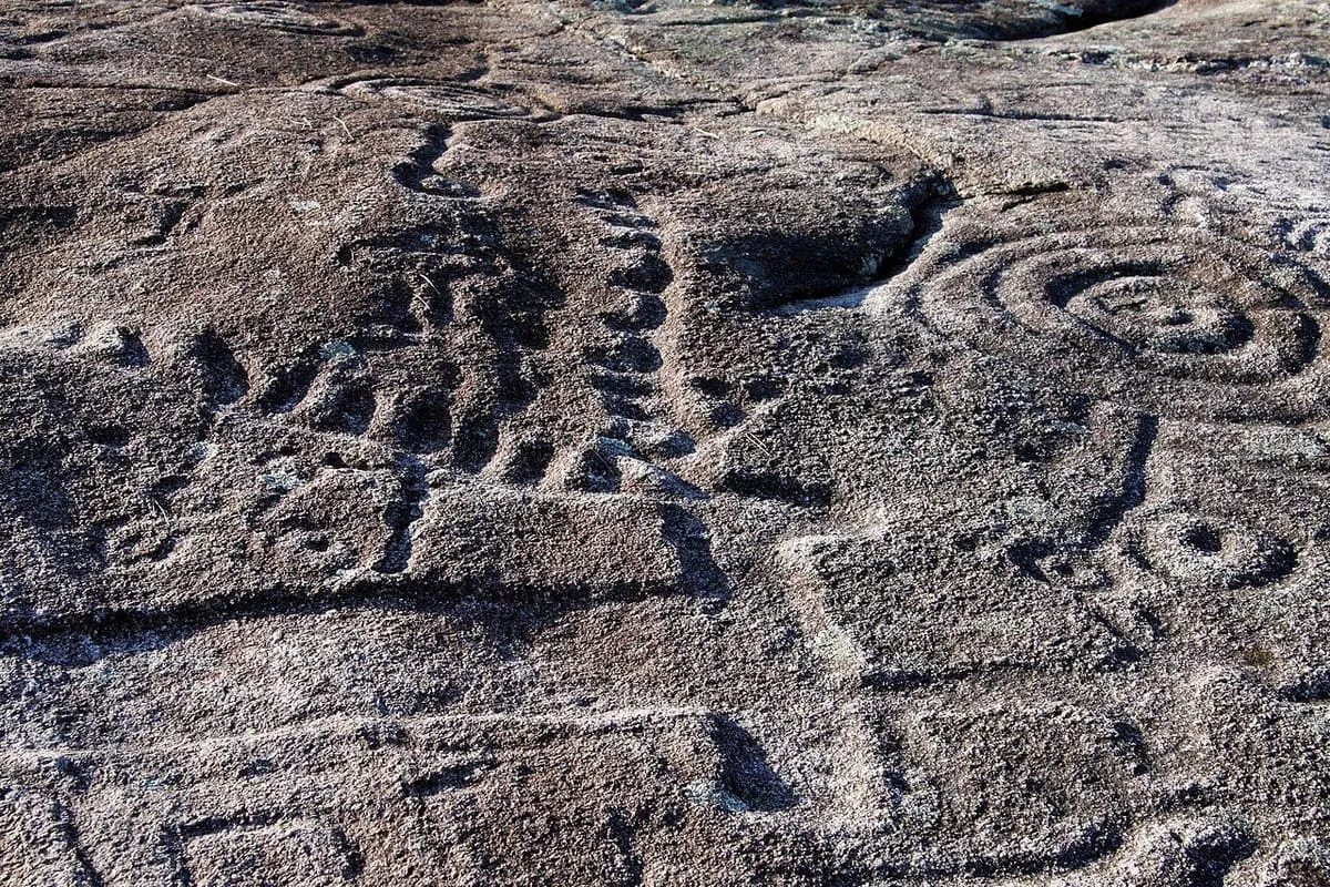 Series de cazoletas y círculos concéntricos grabados en una laxe de granito