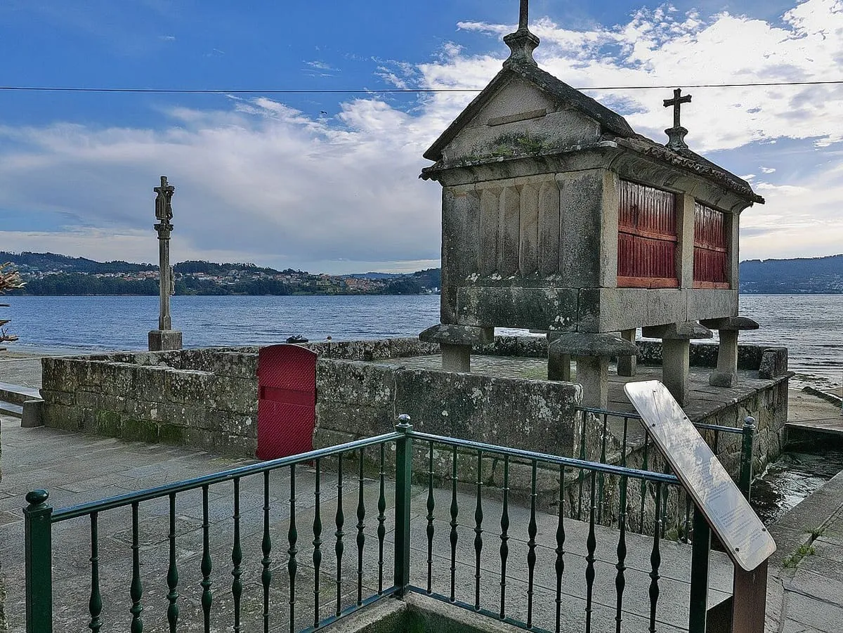 Hórreo de piedra y un cruceiro frente a la ría de Pontevedra, en Combarro