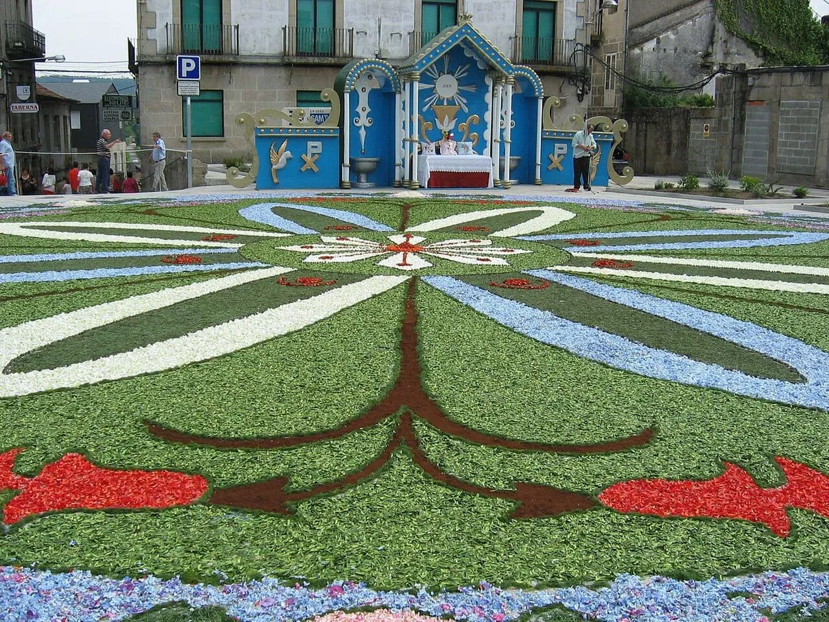 Alfombra de flores con grandes motivos florales frente a un altar azul
