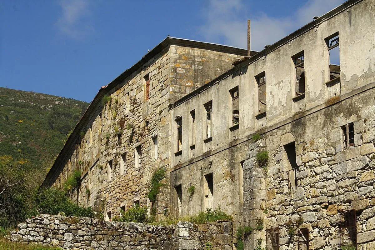 Muro lateral de piedra con filas de ventanas de las dependencias del monasterio
