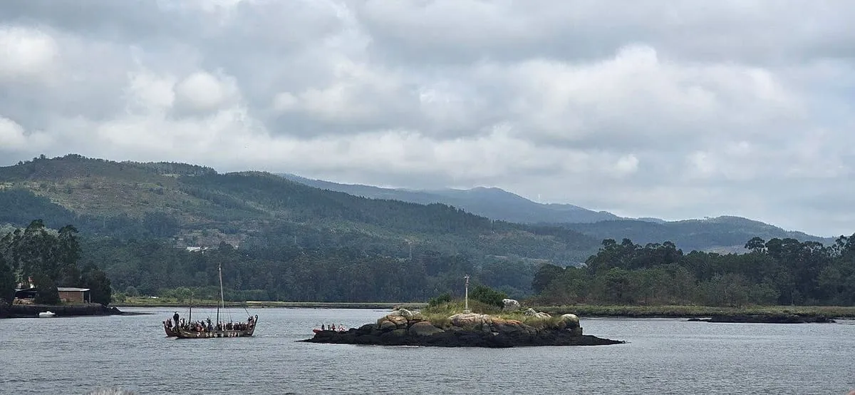 Un barco vikingo navegando por el Ulla junto a la isla de las torres, durante el desembarco de la Romería Vikinga