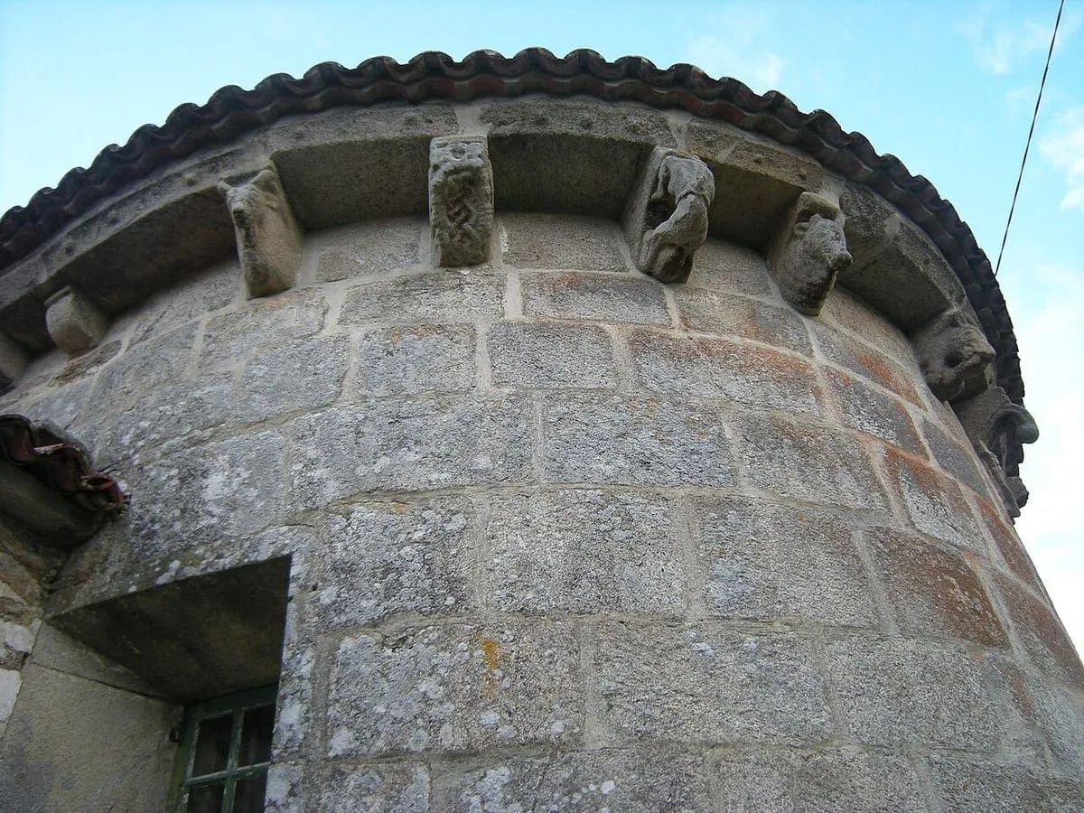 Canecillos esculpidos bajo el alero del ábside de la iglesia de Ouzande