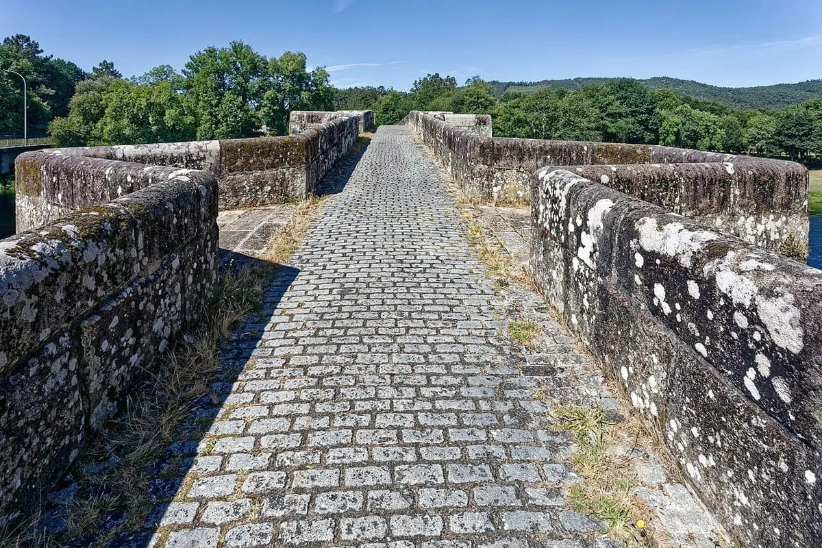 El tablero empedrado de la ponte de Pontevea, estrecho, con pretiles de piedra