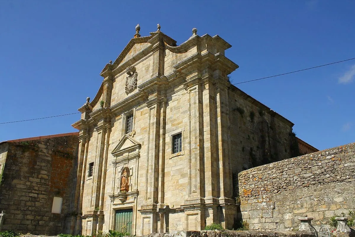 Fachada barroca de piedra de la iglesia, con su hornacina sobre la puerta