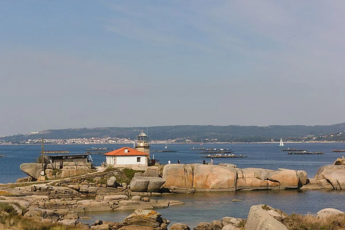 Faro de Punta Cabalo entre rocas de granito, con la ría de Arousa al fondo