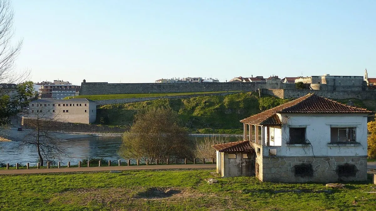 Muralla de la fortaleza abaluartada de Salvaterra de Miño sobre el río, con una casa en primer plano