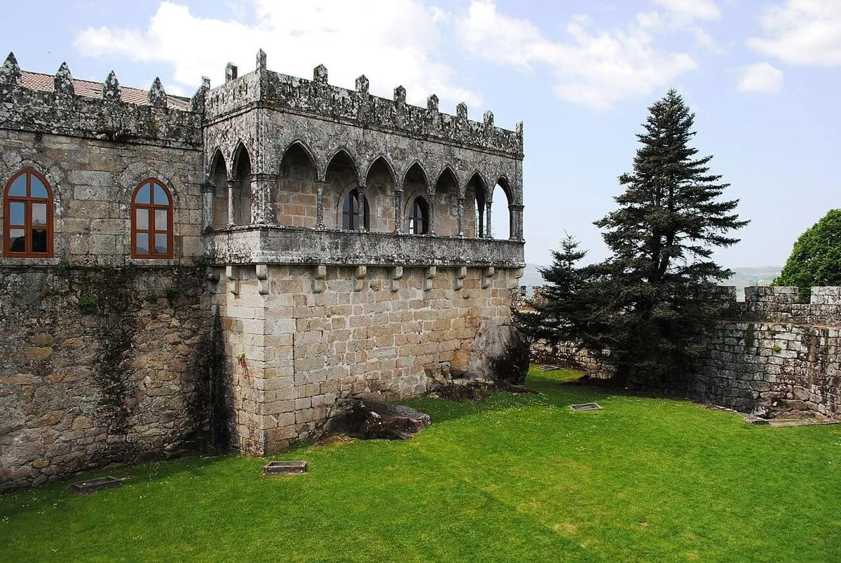 Galería de Damas del castillo de Soutomaior, un corredor de arcos y remates góticos sobre un muro de piedra