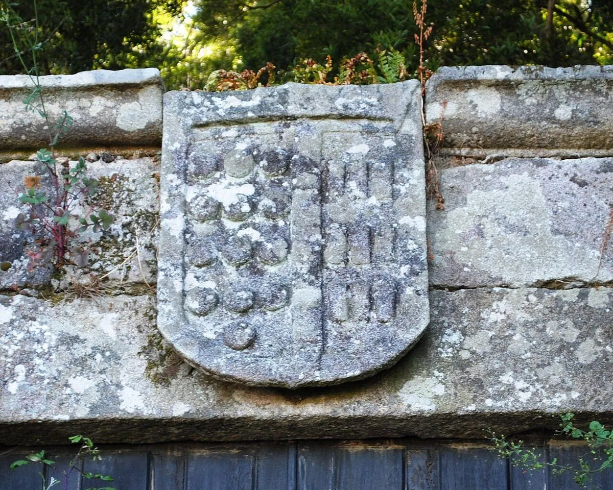 Escudo de armas de los Sarmiento y Acuña tallado en piedra sobre un muro del pazo