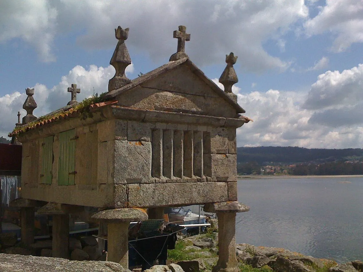 Hórreo de piedra con cruces sobre el agua de la ría, en Combarro
