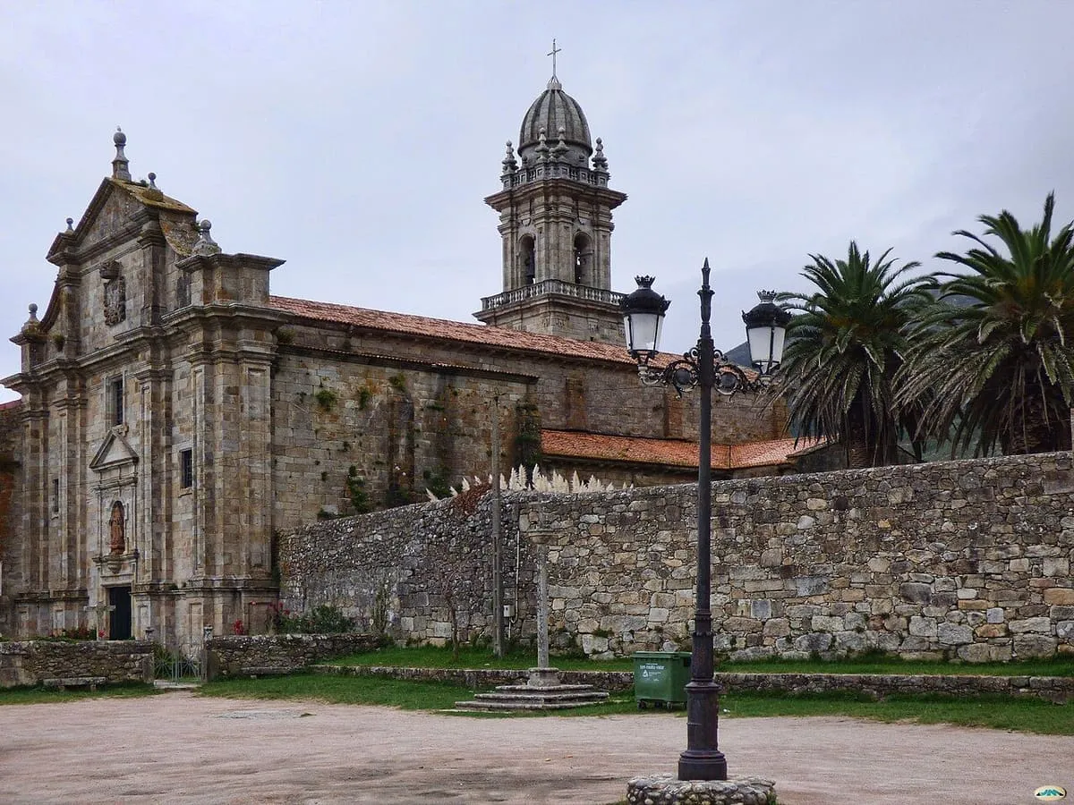 La iglesia del monasterio con su torre barroca y el muro de piedra que la rodea